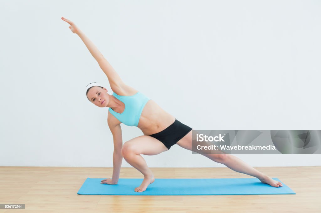 Slim woman doing the side plank yoga pose in fitness studio Full length of a slim young woman doing the side plank yoga pose in fitness studio 20-29 Years Stock Photo Slim woman doing the side plank yoga pose in fitness studio Full length of a slim young woman doing the side plank yoga pose in fitness studio 20-29 Years Stock Photo