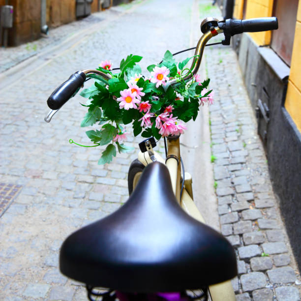 fahrrad mit blumenstrauß am lenker - stockholm sweden gamla stan town square stock-fotos und bilder