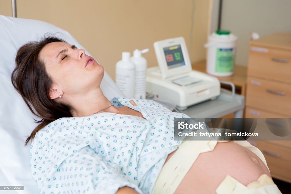 Pregnant woman in delivery room Pregnant woman in delivery room, having contractions Labor - Childbirth Stock Photo