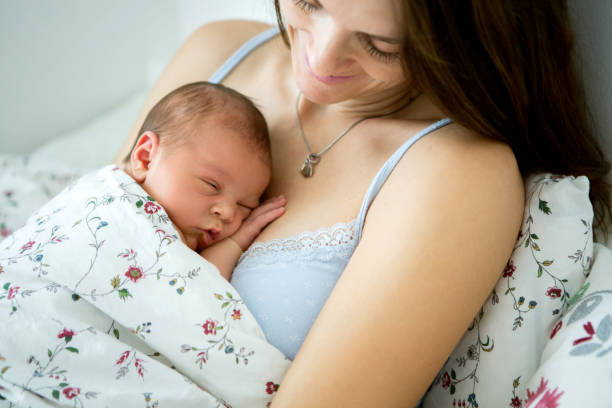 istock Young mother sleeping with her baby, holding him 836183194