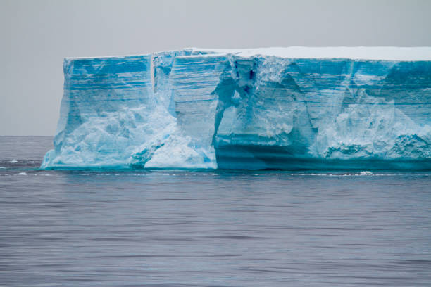 Iceberg drifting in the Antarctic Ocean, dark grey stormy cloudscape. Antarctia.
