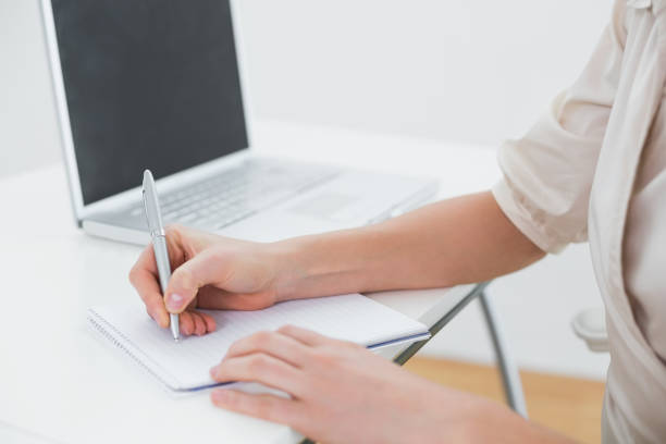 istock Midsection of a businesswoman writing notes by laptop 836226982