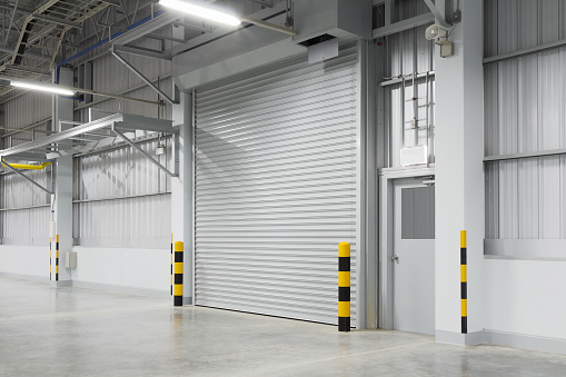 Roller shutter door and concrete floor outside factory building for industry background.