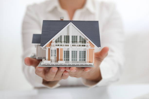 istock Yellow model house in two cupped hands 836234760