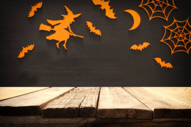 istock Halloween holiday concept. Empty rustic table in front of spider web, witch and bats background 836241136