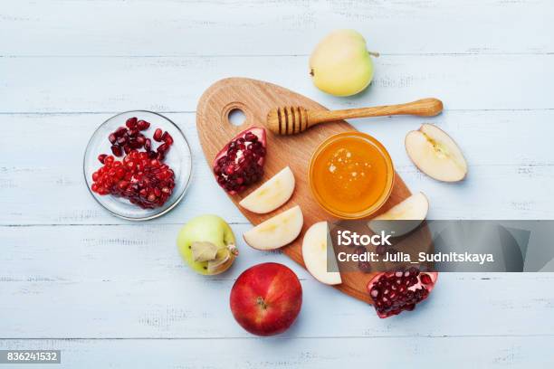 Table Set With Traditional Food For Jewish New Year Holiday Rosh Hashana Honey Apple Slices And Pomegranate Flat Lay Stock Photo - Download Image Now