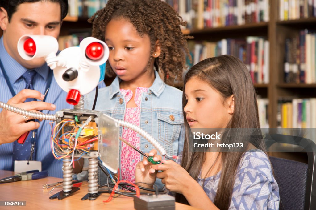 Le ragazze delle scuole elementari costruiscono robot in classe tecnologica. - Foto stock royalty-free di 6-7 anni