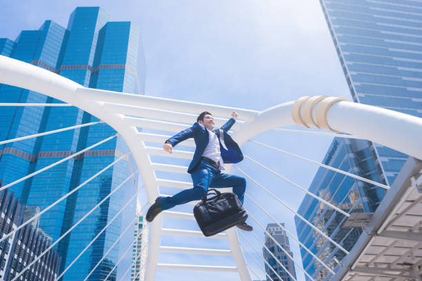 istock Successful businessman jumping with city town background. 836248072