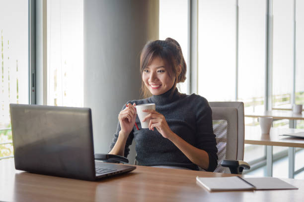 istock Businesswoman working while holding coffee cup in the office 836248544