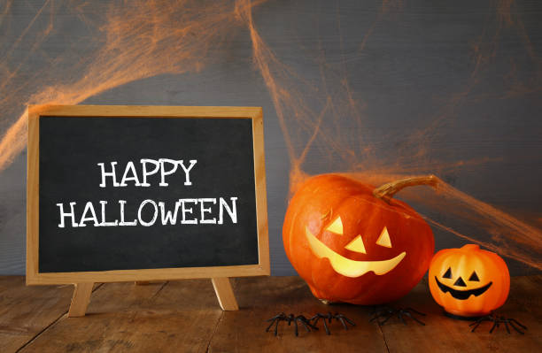 istock Cute pumpkins next to blackboard on wooden table 836248946
