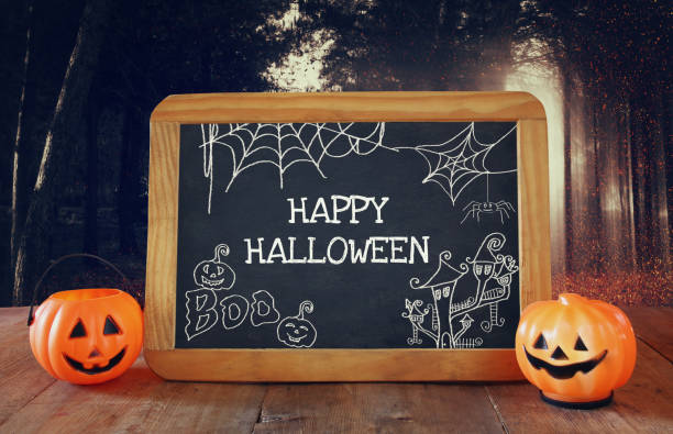 istock Halloween holiday concept. Cute pumpkins next to blackboard 836249014