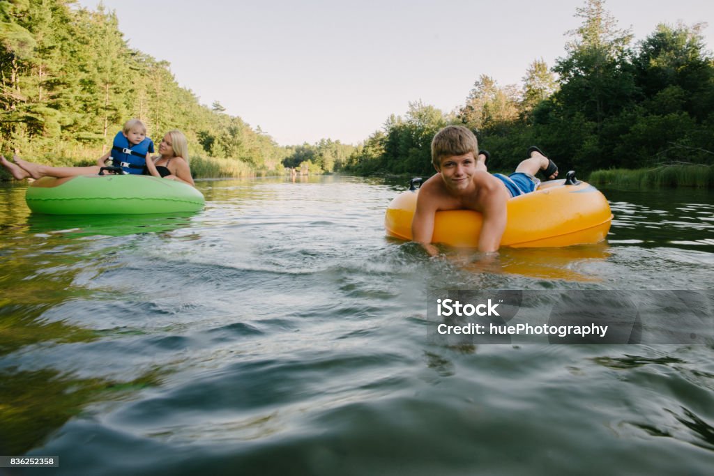 Tubing in river Young people floating down river in inner tubes Traverse City Stock Photo