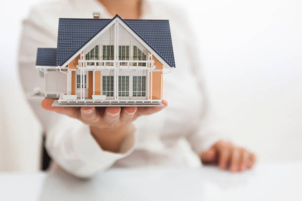 istock Yellow model house in sales person's hand 836255244