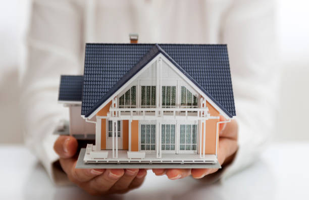 istock Yellow model house in two cupped hands 836258960