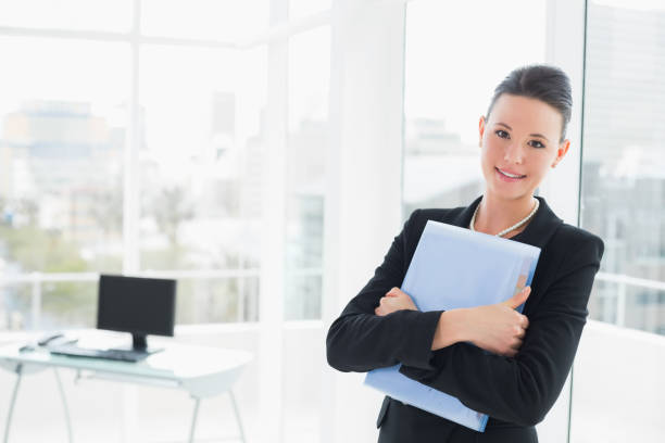istock Elegant businesswoman leaning on glass wall with folder 836262276