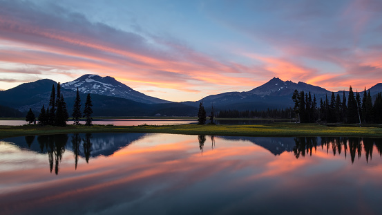 BEND, OREGON - AUGUST 2017 : South Sister and Broken Top are reflected in Sparks Lake at sunset on August 5, 2017 in the Deschutes National Forest, Oregon. Area forest fires resulted in haze.