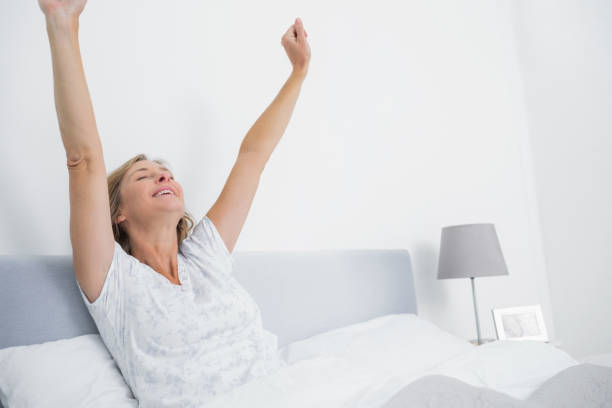 istock Well rested blonde woman stretching in bed and smiling 836273494