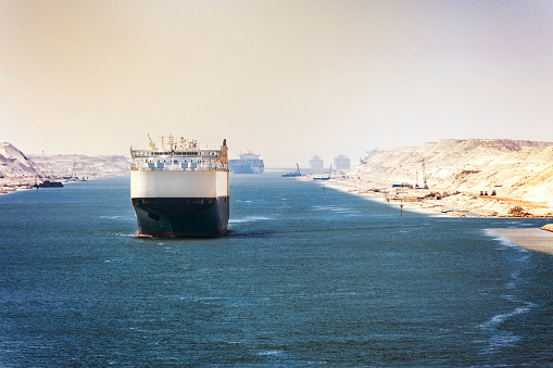 The Suez Canal - a ship convoy passes through the new eastern extension canal, opened in August 2015, pastel colors