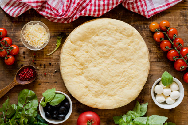 istock Pizza dough and ingredients for making pizza on wooden table 836287222