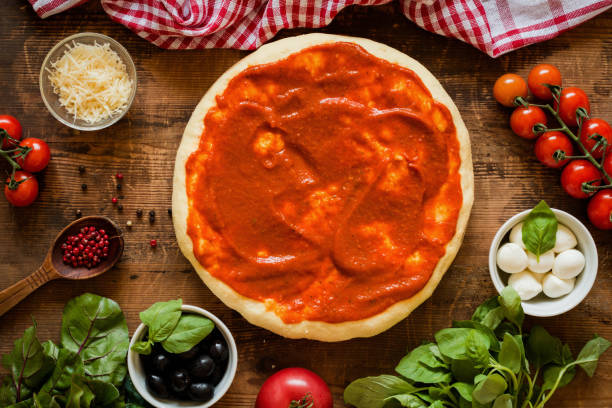 istock Pizza dough with tomato sauce and igredients for pizza. Top view 836287274