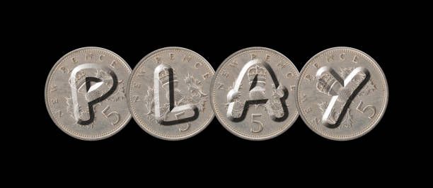 PLAY – Five new pence coins on black background