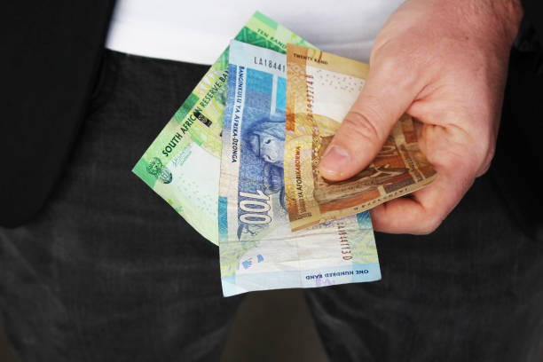 istock A man holding South African money. This image has selective focusing. 836290904