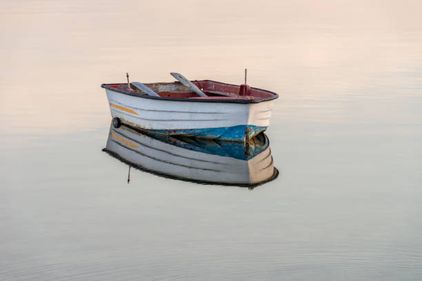 barca da pesca in legno su uno sfondo d'acqua - skiff foto e immagini stock