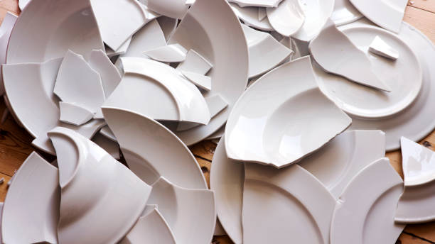 white broken plates on a wooden floor many white broken plates on a wooden floor crockery stock pictures, royalty-free photos & images