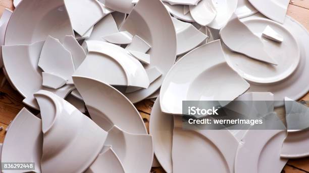 White Broken Plates On A Wooden Floor Stock Photo - Download Image Now - Broken, Plate, Crockery