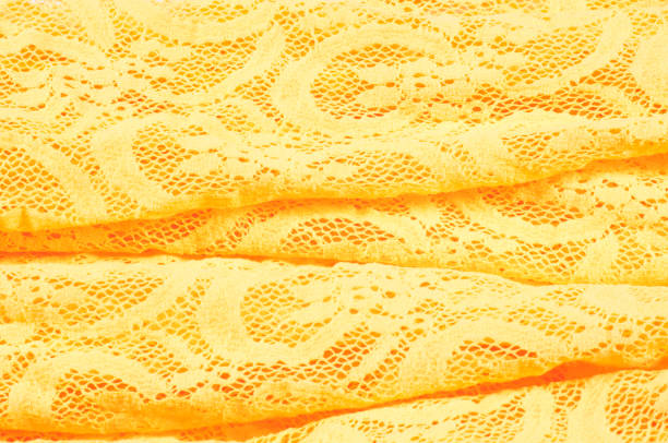 On a blue background, two yellow buttons and yellow lace. Needlework. Accessories for sewing. Copy space.
