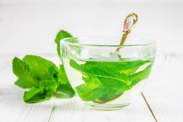 istock Mint tea in a cup on a white wooden table. 836299086