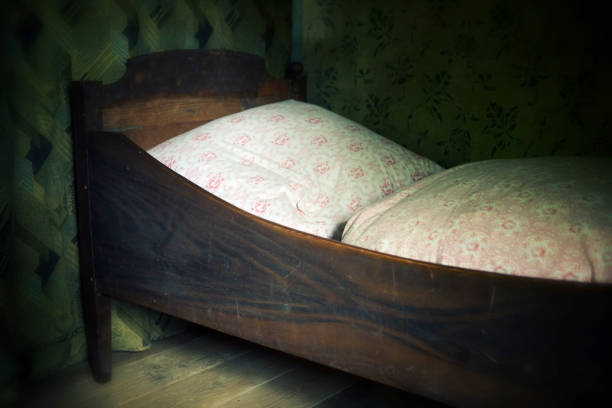 old wooden bed with fluffy pillow and blankets