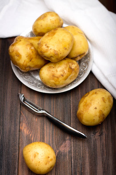 istock Raw potatoes on a brown wooden background 836299340