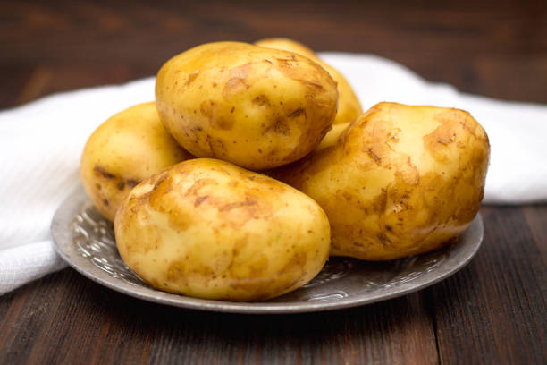 istock Raw potatoes on a brown wooden background 836299378