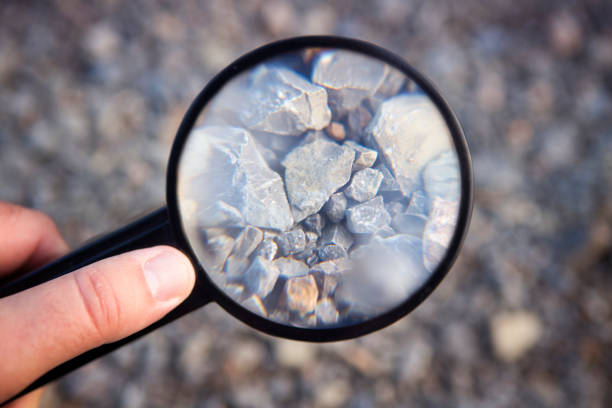 石で虫眼鏡を持っている手 - 地質学 ストックフォトと画像