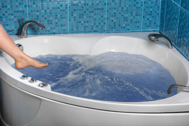 istock Women legs is lowered into the hot tub spa. 836300044
