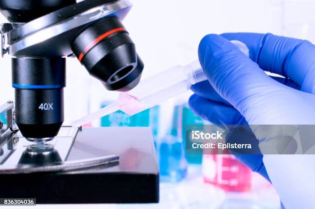 Scientist Pipetting Chemical Liquid On Microscope Slide Examining Samples Laboratory Science Clinic And Research Concept Stock Photo - Download Image Now