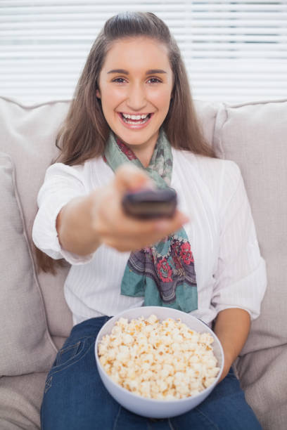 istock Cheerful cute model changing tv channel 836319848