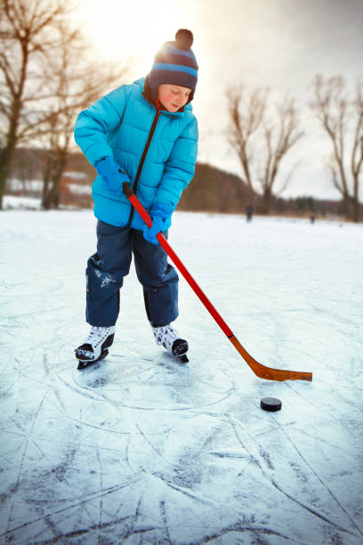 istock Little boy training ice hockey on the pond 836320010
