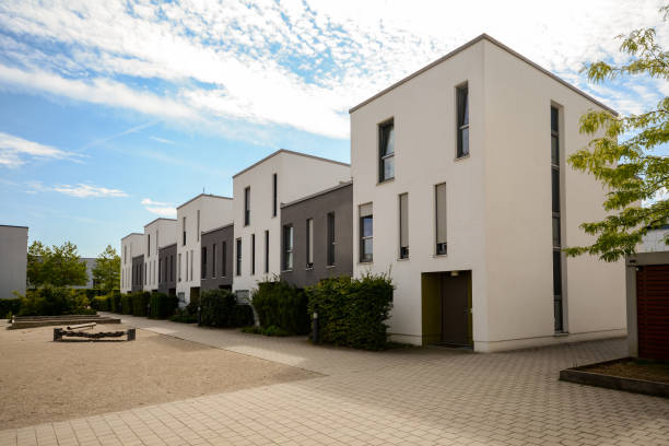 moderne stadthäuser in einem wohngebiet, neue wohnhäuser mit grünen außenanlagen in der stadt - reihenhaus stock-fotos und bilder