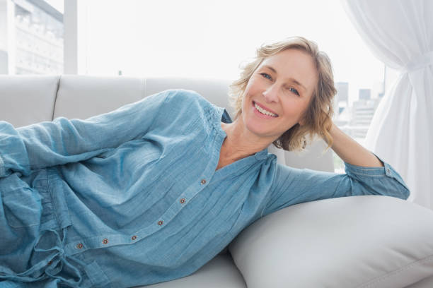 istock Cheerful woman relaxing on her couch 836346568