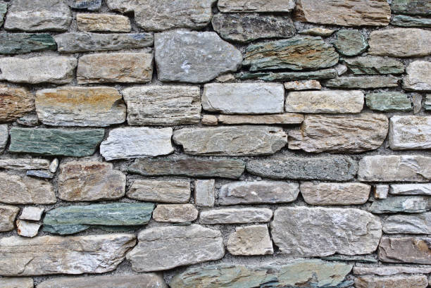 Fieldstone wall with differently sized and coloured stones stock photo
