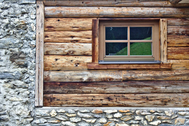 istock Log cabin wall with window and grey field stone foundation 836347206