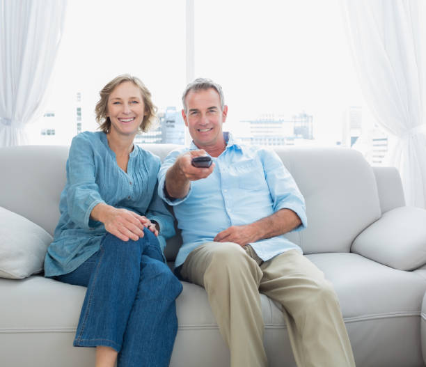 istock Content middle aged couple sitting on the couch watching tv 836347698