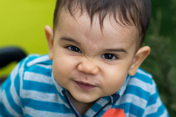 Cute baby boy making an angry face stock photo