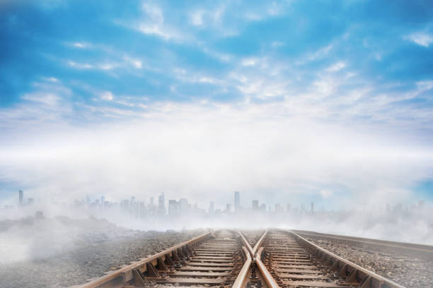 Train tracks leading to city on the cloudy horizon