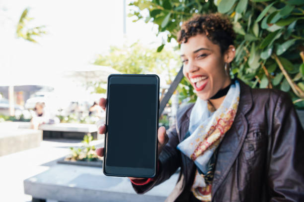 istock Cool Millennial Woman Shows Mobile Phone to Camera Miami 836357270
