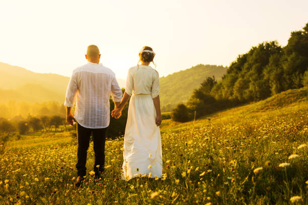 istock Couple walking on the field with sunset view 836357290