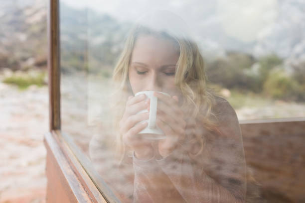 istock Woman drinking coffee through cabin window 836357972