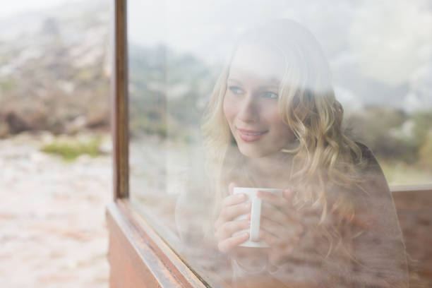 istock Woman with coffee cup looking out through cabin window 836358022